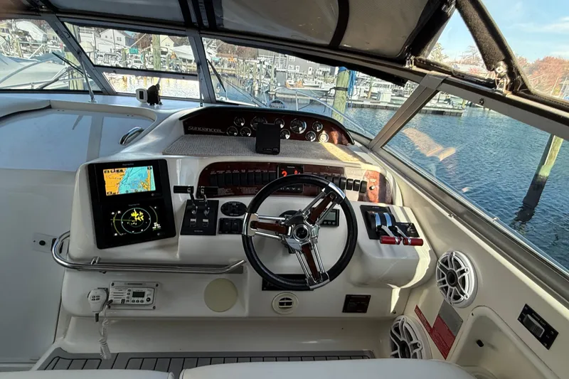 Slide: The Image of 1996 Sea Ray 330 Sundancer helm with navigation equipment and steering wheel, dockside view. - 6