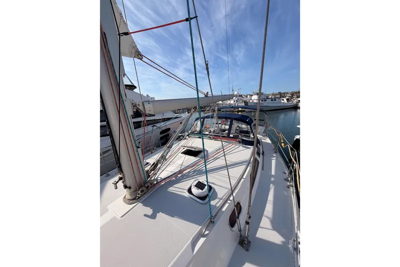 Slide: The Image of 2005 Catalina 42 MkII sailboat docked, showcasing deck and rigging under clear blue sky. - 19