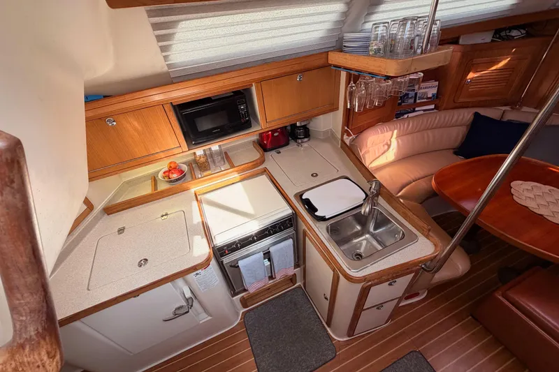 Slide: The Image of Cozy 2005 Catalina 42 MkII yacht interior with kitchen and dining area. - 35