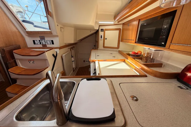 Slide: The Image of Interior of 2005 Catalina 42 MkII sailboat kitchen with sink, microwave, and wooden cabinetry. - 37