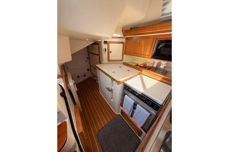 Slide: The Image of Interior of 2005 Catalina 42 MkII sailboat, featuring a compact, well-equipped kitchen area. - 38