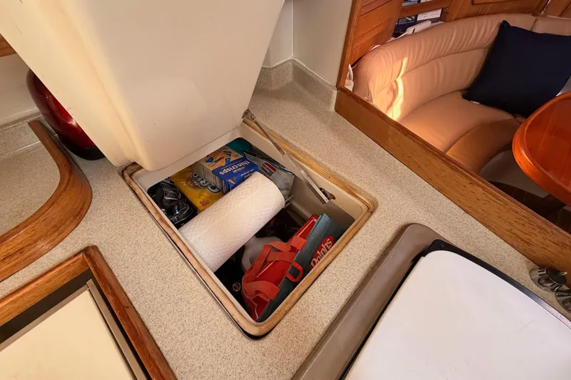 Slide: The Image of Storage compartment in 2005 Catalina 42 MkII yacht galley with supplies and paper towels. - 44