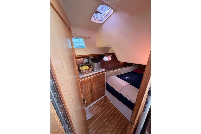 Slide: The Image of Cozy cabin interior of 2005 Catalina 42 MkII sailboat with wooden cabinetry and bedding. - 48