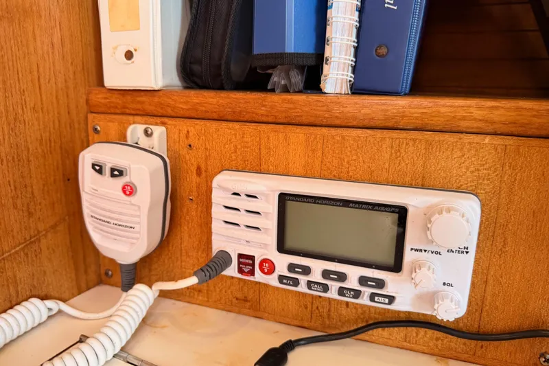 Slide: The Image of VHF radio equipment on a 2005 Catalina 42 MkII sailboat, with manuals and controls. - 61