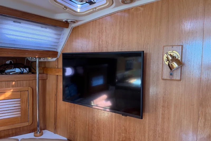Slide: The Image of Interior of 2005 Catalina 42 MkII yacht with mounted TV and brass light fixture. - 62