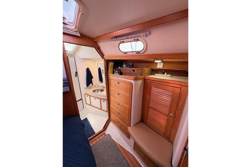 Slide: The Image of Interior of 2005 Catalina 42 MkII sailboat, featuring wooden cabinetry and compact bathroom. - 66