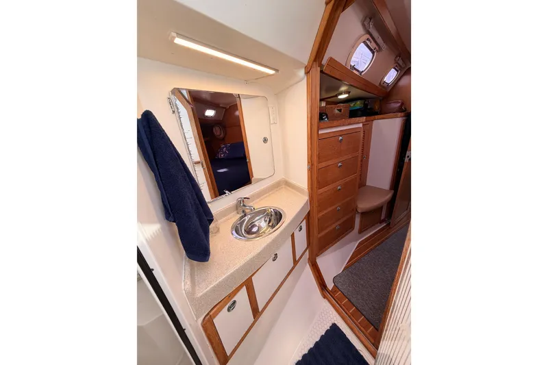 Slide: The Image of 2005 Catalina 42 MkII yacht interior with sink, mirror, and wooden cabinetry. - 72