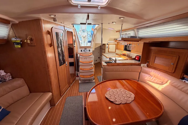 Slide: The Image of Luxurious interior of a 2005 Catalina 42 MkII sailboat with wood finishes and cozy seating. - 78