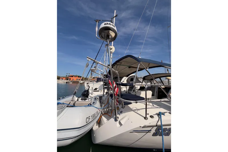 Slide: The Image of Catalina 42 MkII 2005 sailboat docked with inflatable dinghy, clear sky background. - 8