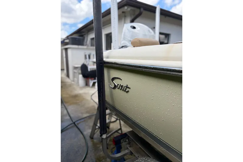 Slide: The Image of 2005 Scout 210 Sportfish boat with visible logo, parked outdoors. - 13