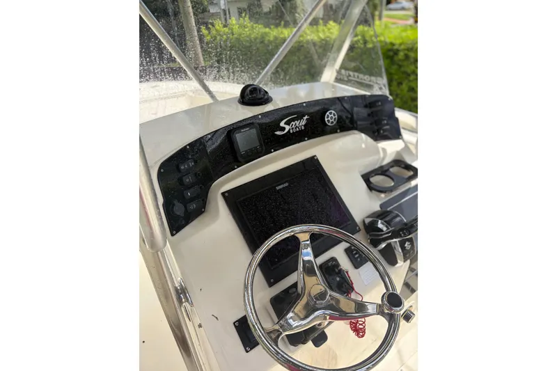 Slide: The Image of 2005 Scout 210 Sportfish boat dashboard with steering wheel and navigation controls. - 3