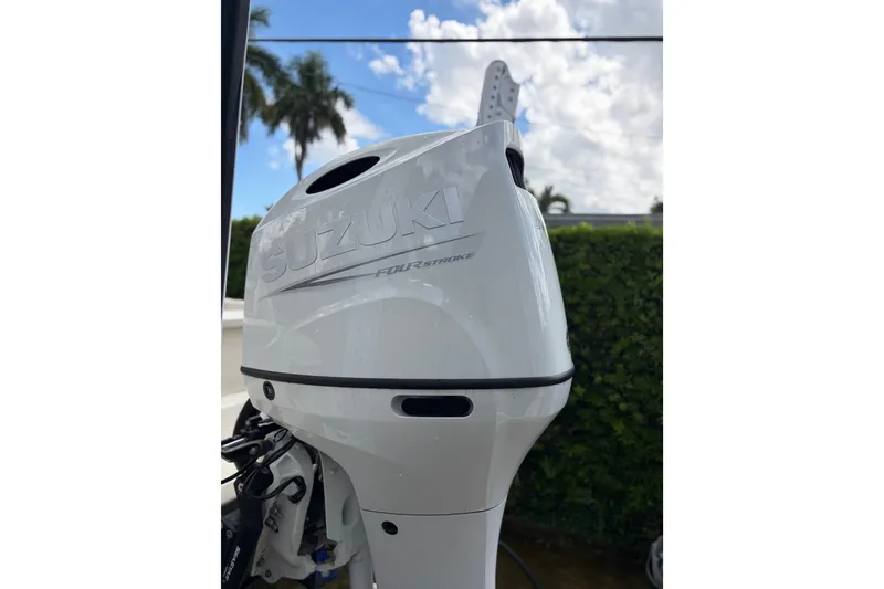 Slide: The Image of Suzuki outboard motor on 2005 Scout 210 Sportfish boat, under a partly cloudy sky. - 4