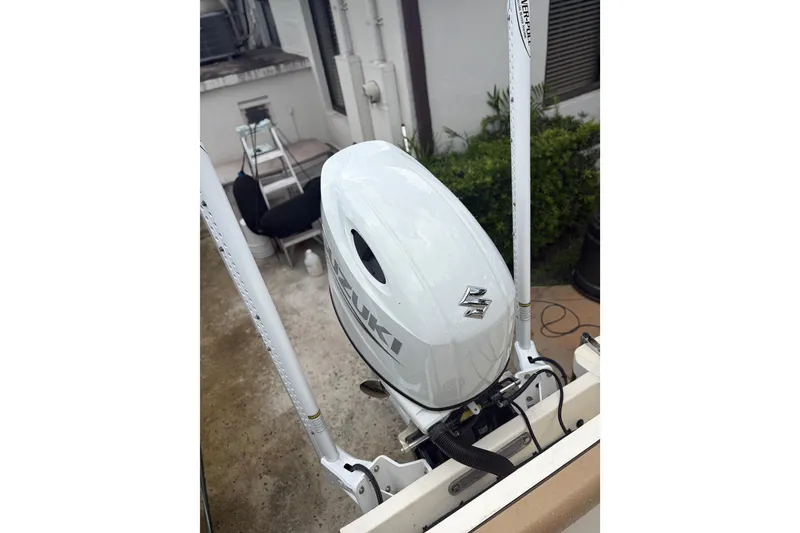 Slide: The Image of 2005 Scout 210 Sportfish with Suzuki outboard motor, parked outdoors. - 6