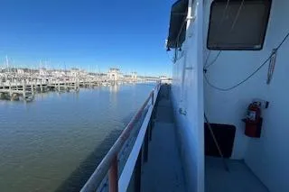Slide: The Image of 1970 Blount 100 Foot Custom Steel Hull docked at marina, clear blue sky. - 46