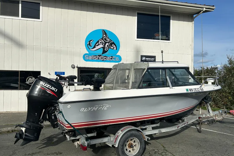Slide: The Image of 1989 Olympic 17 Cabin boat on trailer outside Salish Boat Co. with Suzuki outboard motor. - 1