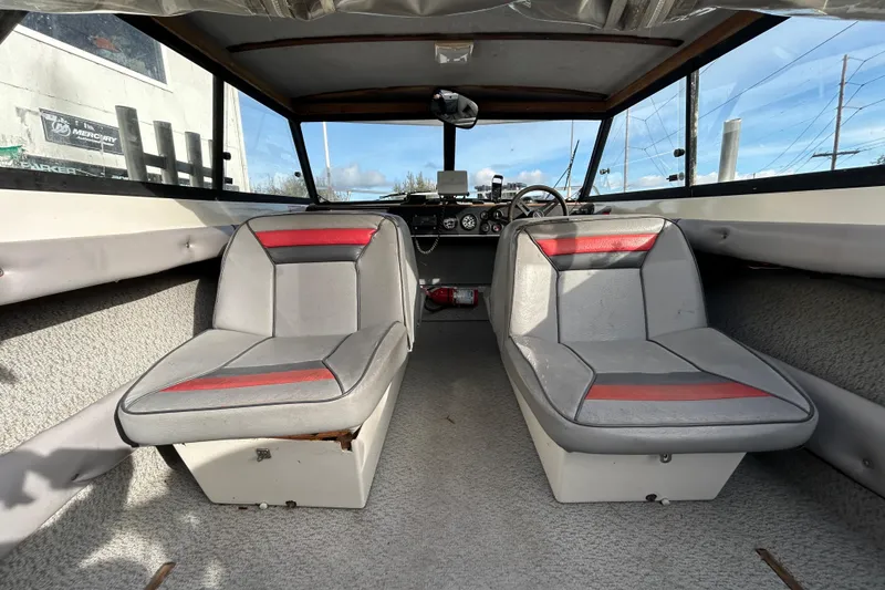 Slide: The Image of Interior of a 1989 Olympic 17 Cabin boat with dual gray and red seats. - 2