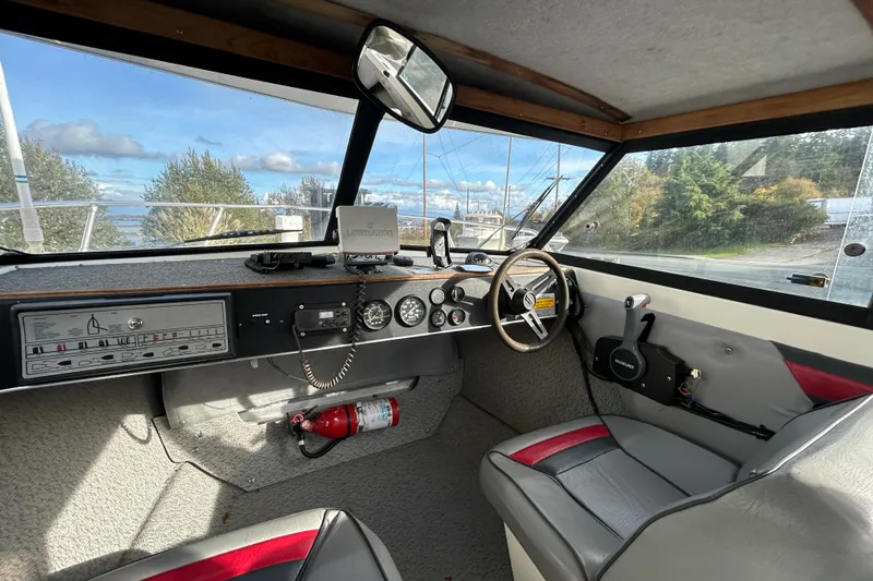Slide: The Image of Interior of 1989 Olympic 17 Cabin boat with steering wheel and dashboard controls. - 3