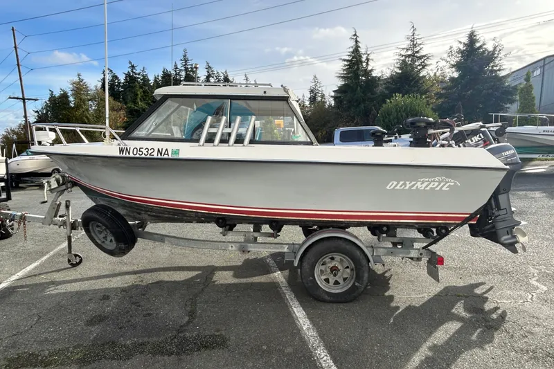Slide: The Image of 1989 Olympic 17 Cabin boat on trailer, parked outdoors, with visible registration number. - 5