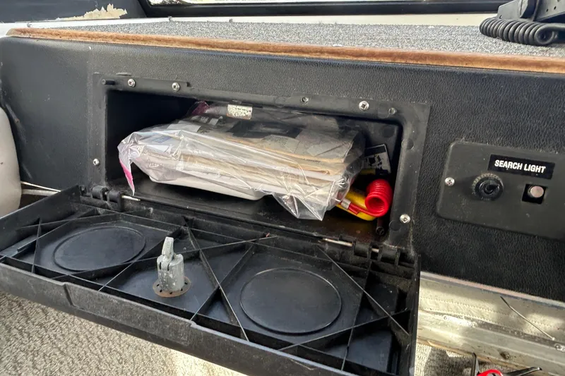 Slide: The Image of Interior of 1989 Olympic 17 Cabin boat showing storage compartment and search light switch. - 6