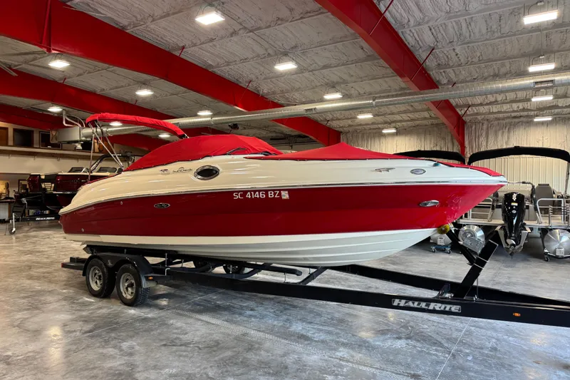 Slide: The Image of 2008 Sea Ray 240 Sundeck boat in showroom, red and white, on trailer. - 12