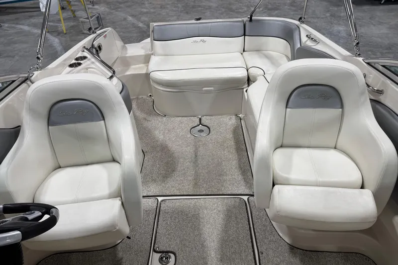 Slide: The Image of 2008 Sea Ray 240 Sundeck interior with white and gray seating, carpeted floor. - 8