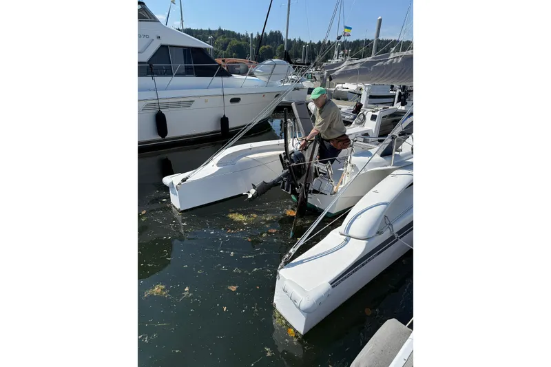 Slide: The Image of Man on Dragonfly 25 sailboat in marina, surrounded by other boats, 2022 model. - 14