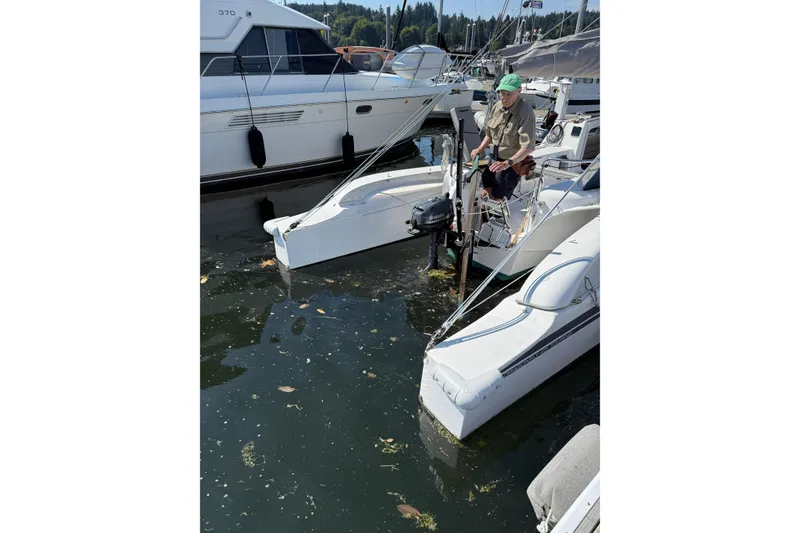 Slide: The Image of Man on Dragonfly 25 trimaran at marina, 2022 model, surrounded by boats. - 15