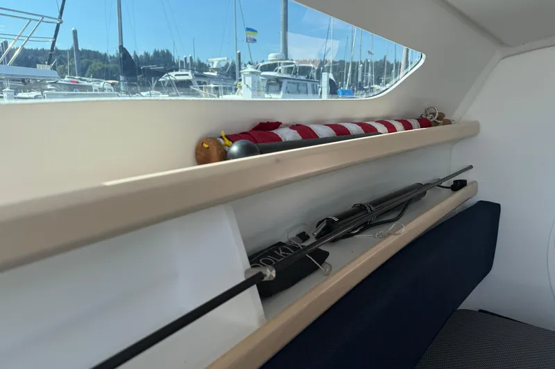 Slide: The Image of Interior of a 2022 Dragonfly 25 sailboat with storage shelves and marina view. - 21