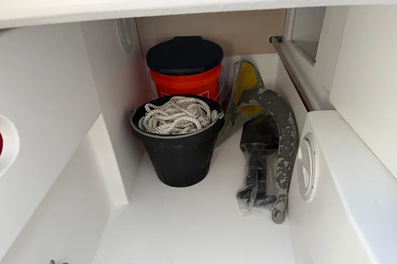 Slide: The Image of Storage compartment in a 2022 Dragonfly 25 boat with rope, bucket, and anchor. - 27