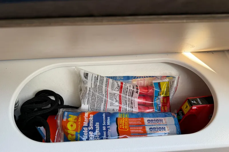 Slide: The Image of Storage compartment in a 2022 Dragonfly 25, containing marine safety equipment and rope. - 29
