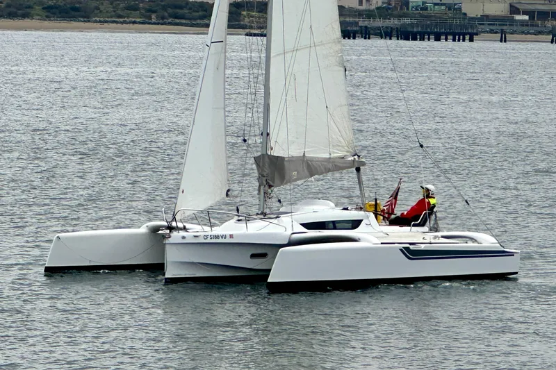 Slide: The Image of 2022 Dragonfly 25 trimaran sailing on calm waters near a shoreline. - 3