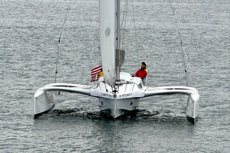 Slide: The Image of 2022 Dragonfly 25 trimaran sailing on calm waters with a person onboard. - 4