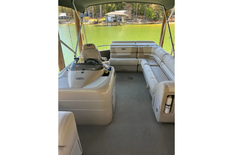 Slide: The Image of 2010 Harris FloteBote 220 Sunliner interior with beige seating and steering console. - 2