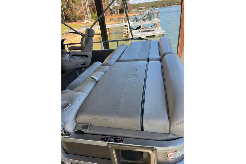 Slide: The Image of 2010 Harris FloteBote 220 Sunliner pontoon boat with comfortable seating by a lakeside dock. - 4