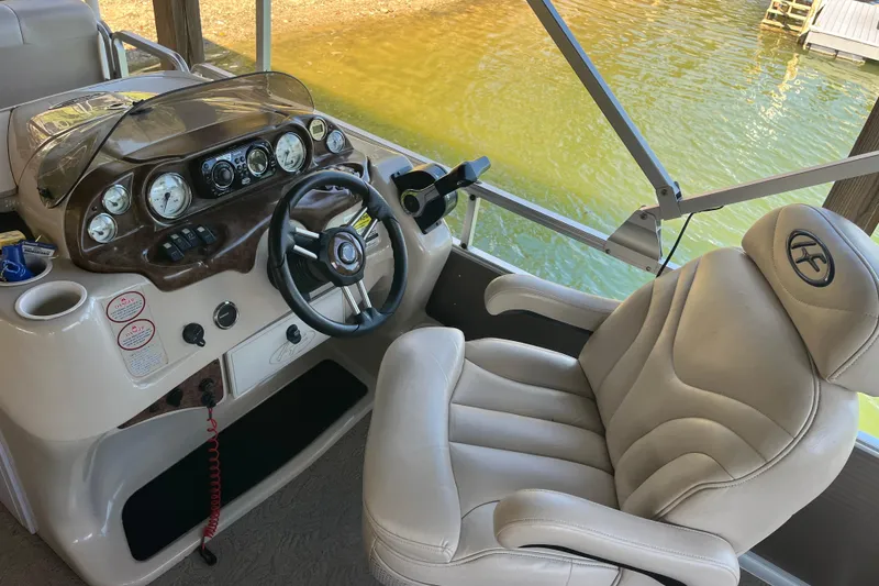 Slide: The Image of Captain's chair and dashboard of a 2010 Harris FloteBote 220 Sunliner pontoon boat. - 5