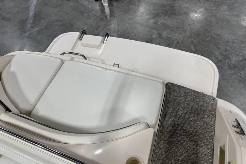 Slide: The Image of 2004 Rinker 282 BR boat interior with white seating and gray flooring. - 14