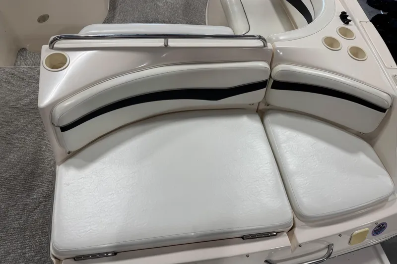 Slide: The Image of 2004 Rinker 282 BR boat interior with white cushioned seating and cup holders. - 16