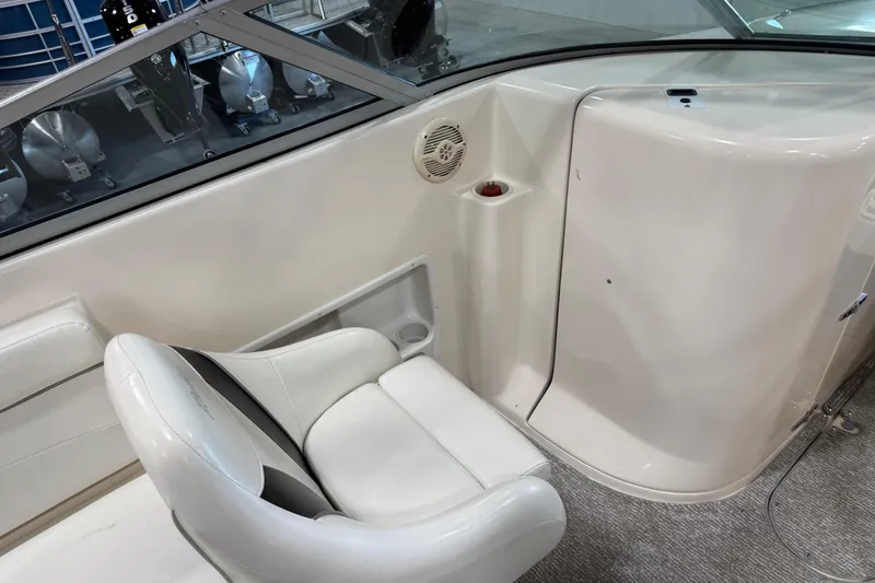 Slide: The Image of 2004 Rinker 282 BR boat interior with white seating and speaker detail. - 8