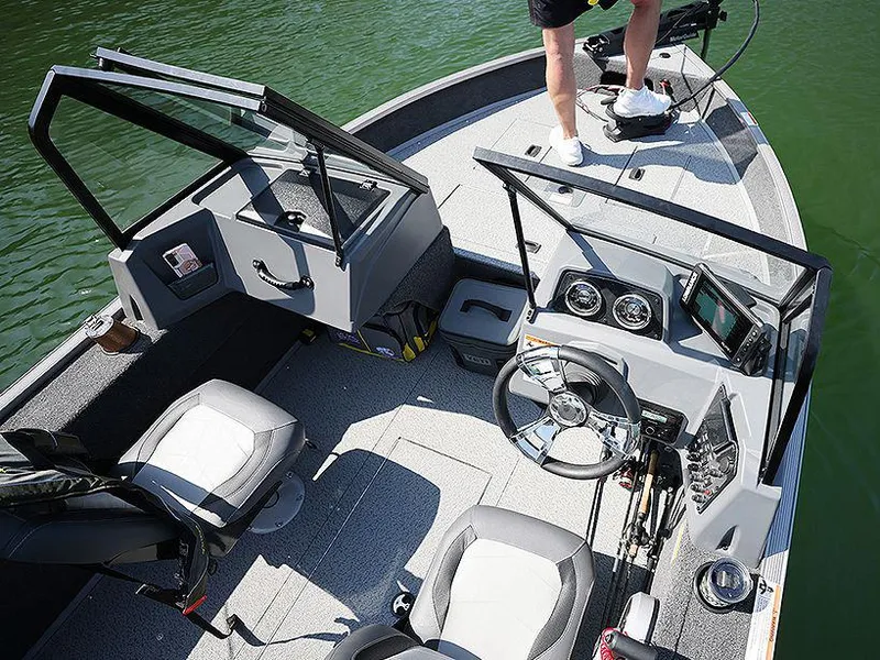 Slide: The Image of Manufacturer Provided Image: 2025 Lowe Fishing Machine 1625 WT interior with steering console and seating on a lake. - 2