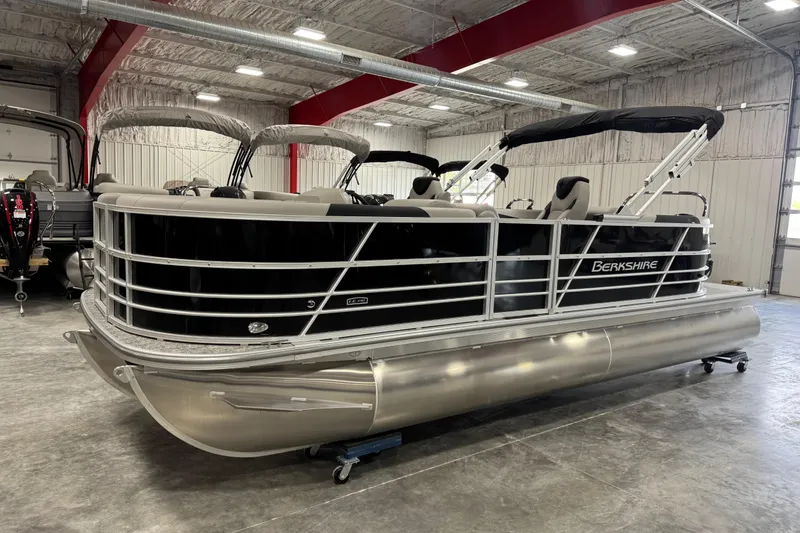 The Image of 2026 Berkshire 22 UL LE pontoon boat in a showroom, featuring sleek design and modern amenities. - 1