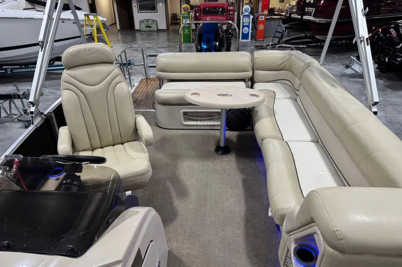 Slide: The Image of 2012 Harris Grand Mariner 250 pontoon boat interior with beige seating and table. - 10