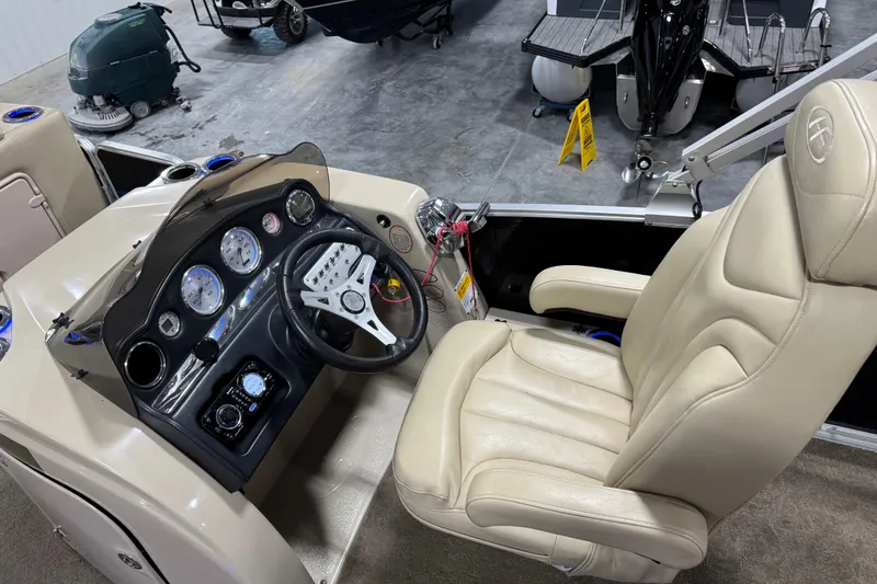 Slide: The Image of 2012 Harris Grand Mariner 250 boat cockpit with beige captain's chair and control panel. - 13