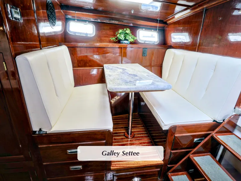 Slide: The Image of 1968 Stephens Motor Yacht galley settee with white cushions and wooden interior. - 15