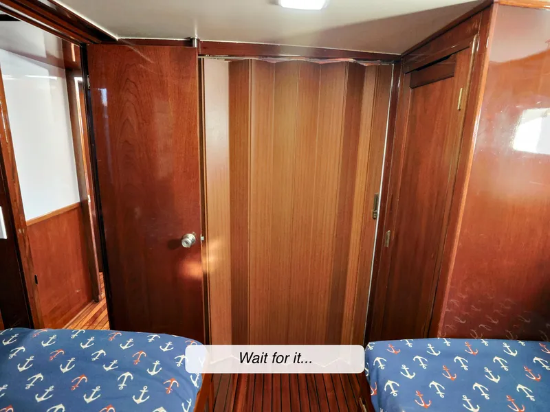 Slide: The Image of Interior of 1968 Stephens Motor Yacht with wooden paneling and nautical-themed bedding. - 21
