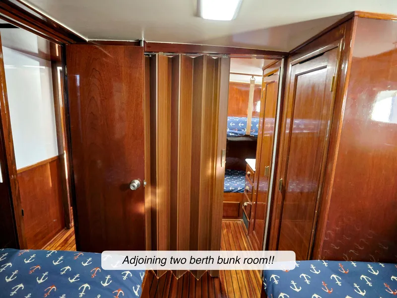 Slide: The Image of Interior of 1968 Stephens Motor Yacht with adjoining two-berth bunk room, wooden paneling, and nautical decor. - 22