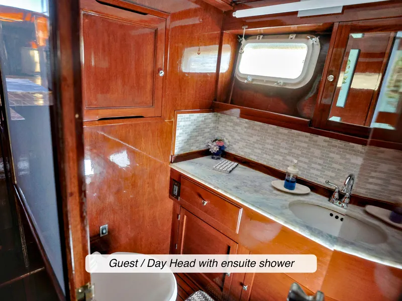 Slide: The Image of 1968 Stephens Motor Yacht guest bathroom with wood finish and ensuite shower. - 26