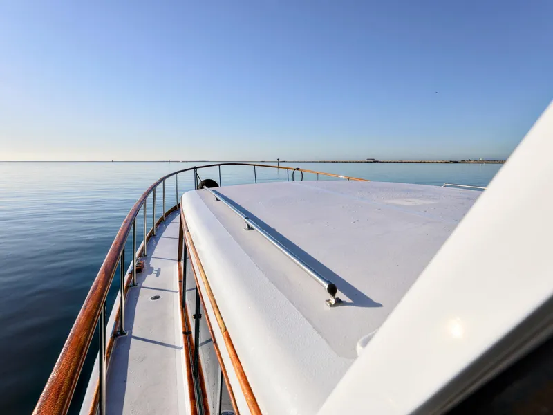 Slide: The Image of 1968 Stephens Motor Yacht deck with wooden railings on calm water. - 40