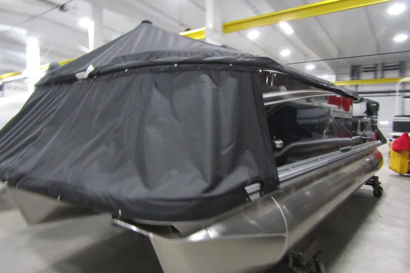 Slide: The Image of 2025 Avalon LSZ Cruise pontoon boat with cover in a warehouse setting. - 14