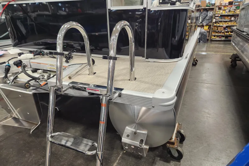 Slide: The Image of 2025 Avalon LSZ Cruise pontoon boat with ladder in a showroom. - 2