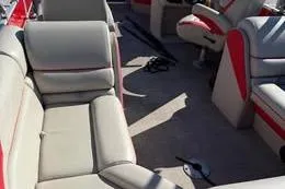 Slide: The Image of 2024 South Bay 2.75 Triple Toon LE pontoon boat interior with beige and red seating. - 30